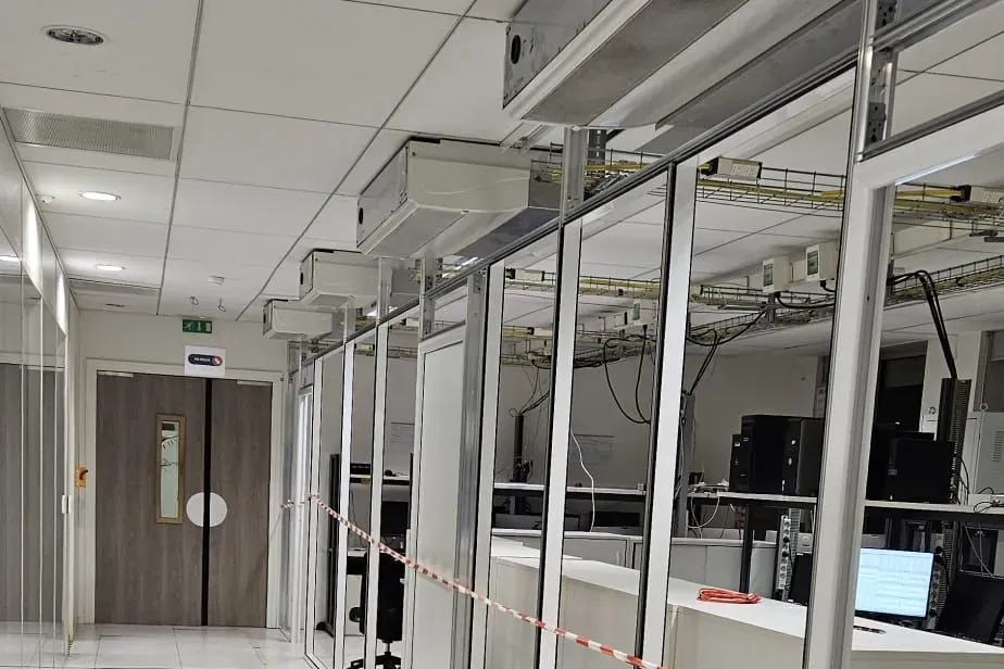 Cloisons vitrées et chemins de câbles suspendus au-dessus des postes techniques du plateau
