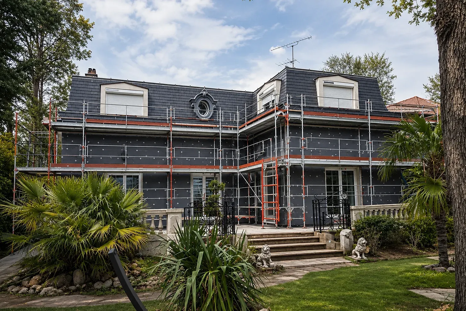 Façade de la villa pendant les travaux : panneaux d'isolation thermique par l'extérieur et échafaudage