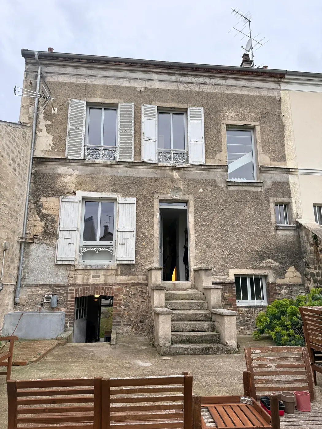 Vue d'ensemble de la façade avant ravalement, avec l'escalier en pierre menant à l'entrée